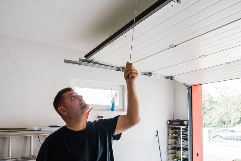 Garage door balance test by Santos & Sons in San Mateo — technician manually testing door weight distribution