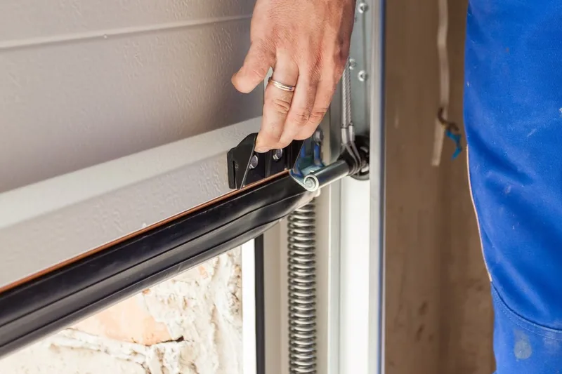 Professional garage door tune-up service by Santos & Sons in San Mateo, CA — technician inspecting springs and rollers